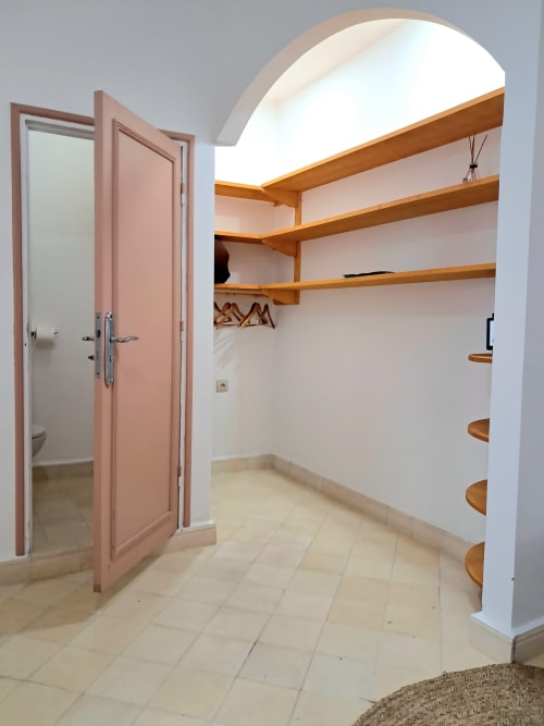 Walk-in closet with wooden shelves and arched ceiling at Vent Des Dunes & Spa, Essaouira