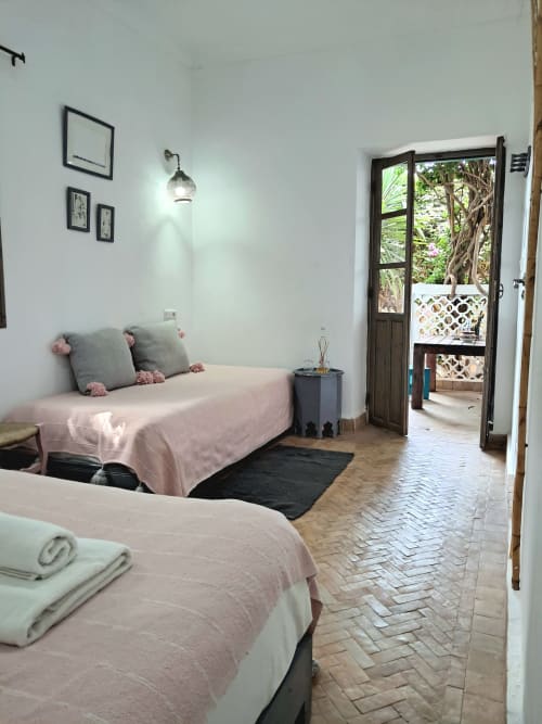 Triple bedroom with pink beds, garden view, and private terrace at Vent Des Dunes & Spa, Essaouira