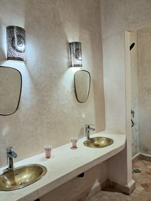 Luxury bathroom with dual brass sinks, ornate wall sconces, and mirrors at Vent Des Dunes & Spa, Essaouira