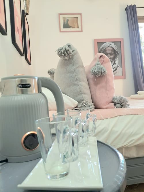 Vent Des Dunes hotel room detail: kettle, glasses, and decorative cushions on table