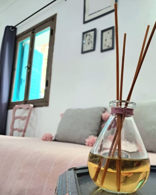 Reed diffuser with golden liquid on table in Vent Des Dunes & Spa hotel room in Essaouira, Morocco