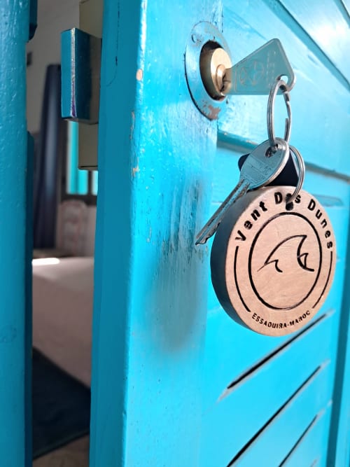 Brass keychain on bright turquoise door at Vent Des Dunes & Spa, Essaouira hotel with garden view