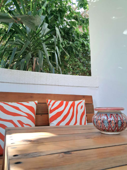 Wooden terrace with red and white zebra-striped cushions at Vent Des Dunes hotel in Essaouira