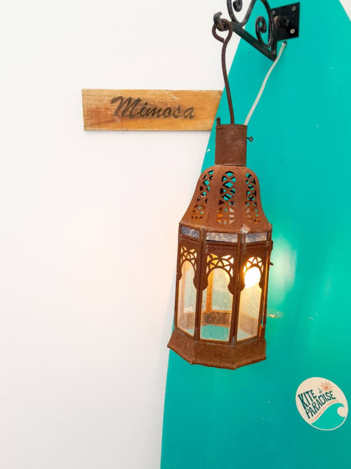 Decorative lantern hanging on turquoise wall at Vent Des Dunes & Spa, Essaouira with Mimosa room sign
