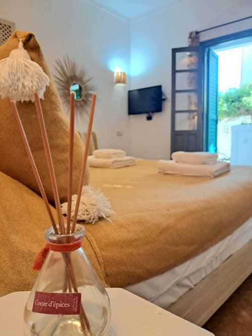 Coeur d'épices diffuser on bed in Mimosa room at Vent Des Dunes & Spa, Essaouira with terrace view