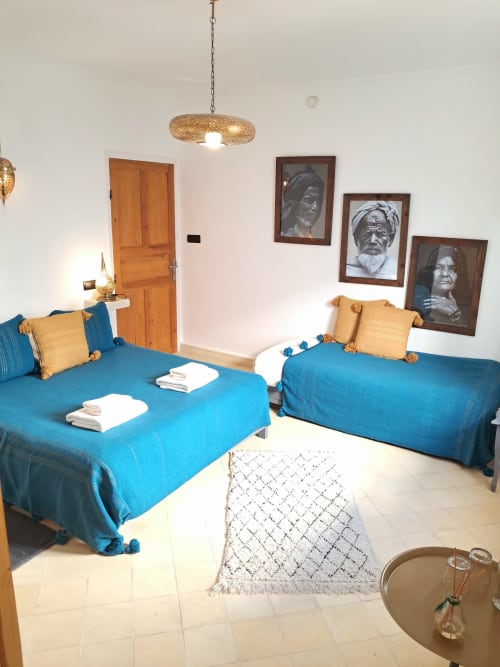Triple room with blue beds and gold pillows at Vent Des Dunes & Spa in Essaouira, featuring Moroccan decor and terrasse