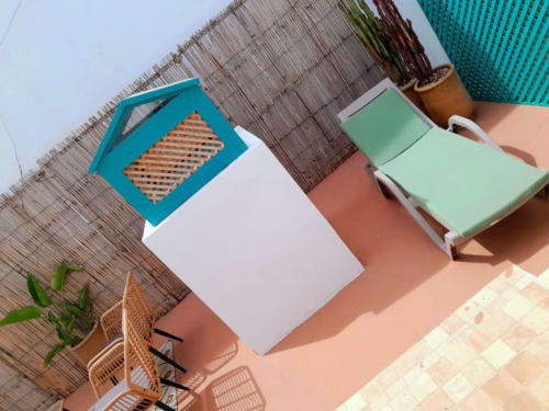 Terrace at Vent Des Dunes & Spa in Essaouira with colorful sunbed, potted plants, and wooden deck overlooking city