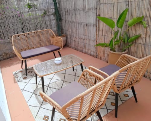 Cozy terrace seating area at Vent Des Dunes & Spa in Essaouira with woven chairs, coffee table, and potted plant