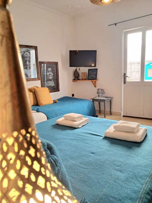 Bright bedroom with twin beds, blue bedding, and white towels at Vent Des Dunes hotel in Essaouira