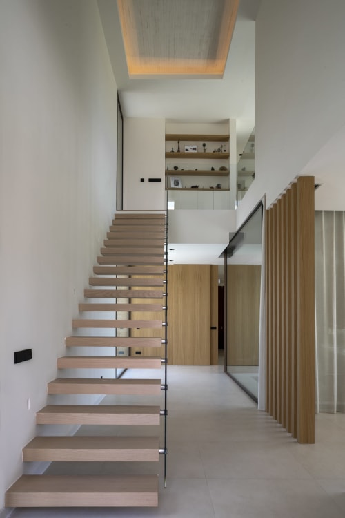 Escalera moderna con peldaños de madera y barandilla de cristal en Villa Ona, Riurau Home, Calp, España