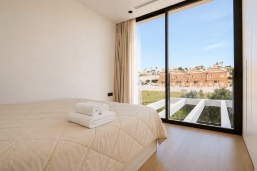 Moderno dormitorio en Villa Ona de Riurau Home, Calp, con vistas al océano y mobiliario contemporáneo con vista al Mediterráneo