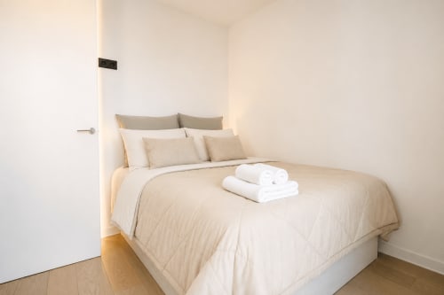 Dormitorio amplio en Villa Ona de Riurau Home, Calp, con ropa de cama beige, múltiples almohadas y toallas blancas