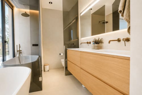 Baño de lujo moderno en Villa Ona de Calp con vanidad de madera, doble lavamanos, espejo iluminado y bañera exenta