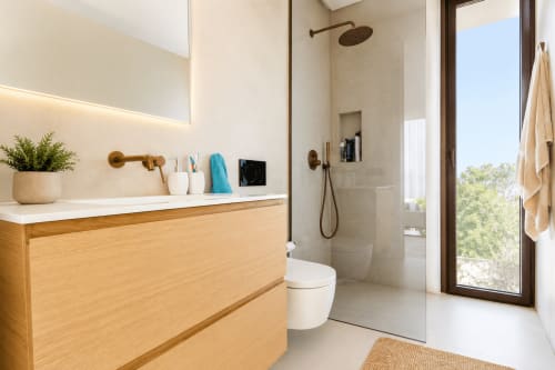 Baño moderno en Villa Ona de Riurau Home, Calp con tocador de madera, ducha de lluvia y vistas al jardín