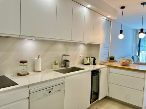 Cocina moderna blanca en cottage Solana Urban Lux, Fuengirola con backsplash de mármol, electrodomésticos de acero inoxidable y lámparas colgantes