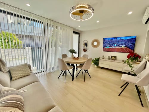 Elegante sala de estar en Solana Urban Lux, Fuengirola, con comedor, asientos cómodos, TV y vistas a la ciudad