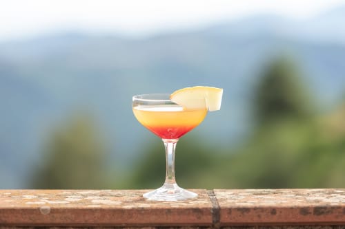 Cocktail coloré avec garnish d'ananas à l'hôtel Allegria à Bajardo, vue panoramique sur les montagnes