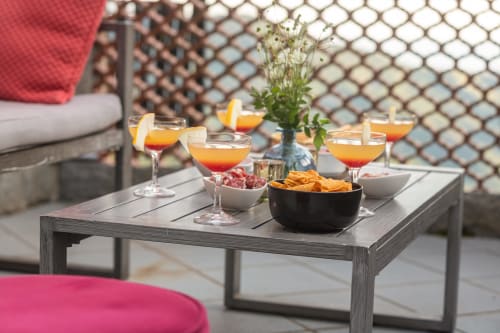 Terrasse extérieure de l'hôtel Allegria à Bajardo avec cocktails, amuse-bouches et fleurs fraîches sur une table