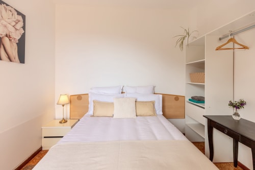 Chambre Armonia de l'hôtel Allegria à Bajardo avec lit en bois, murs blancs et vue sur les montagnes