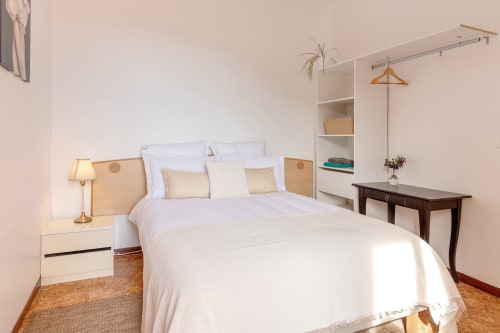 Chambre Armonia de l'hôtel Allegria à Bajardo avec literie blanche, tête de lit en bois et vue sur les montagnes