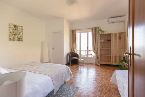 Chambre spacieuse à l'hôtel Allegria à Bajardo avec lits jumeaux, armoire en bois, balcon avec vue sur les montagnes et design moderne