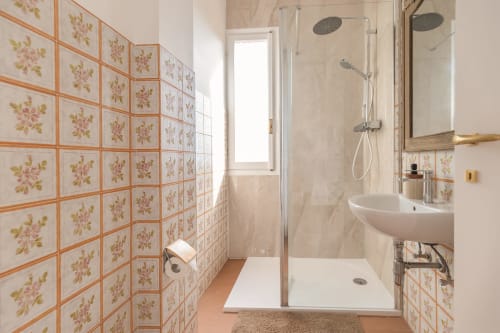 Salle de bain moderne de l'Hôtel Allegria à Bajardo avec carrelage à motifs floraux, douche à l'italienne, lavabo et miroir chauffant