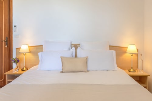 Chambre Calma de l'hôtel Allegria à Bajardo avec literie blanche, lampes de chevet et vue sur les montagnes