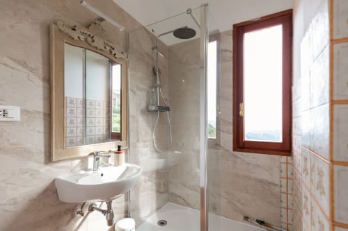 Salle de bains moderne à l'hôtel Allegria à Bajardo avec douche à l'italienne, carrelage en marbre et vue sur les montagnes