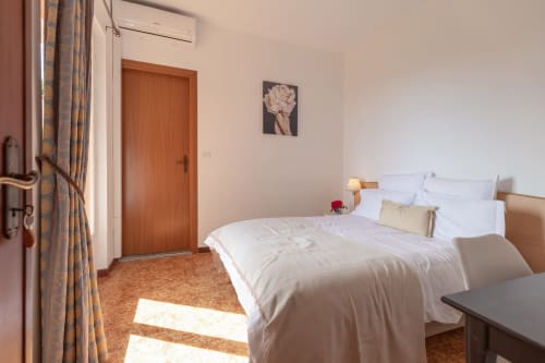 Chambre Felice à l'hôtel Allegria à Bajardo avec lit queen-size, porte en bois et lumière naturelle