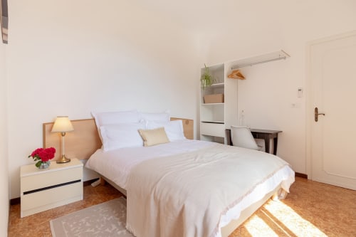 Chambre lumineuse à l'Hôtel Allegria à Bajardo avec lit en bois, literie blanche et sol en liège