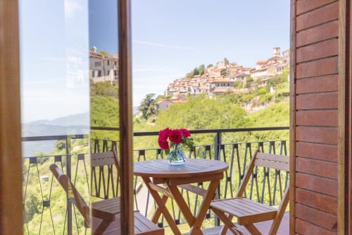 Vue depuis la terrasse de l'Hôtel Allegria à Bajardo, avec roses rouges et table en bois dominant la campagne italienne