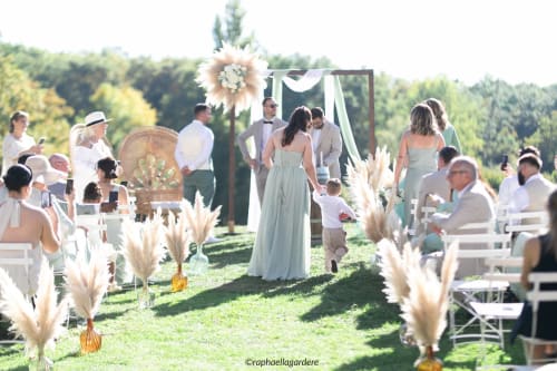 Outdoor wedding ceremony at Château ERIGOYE with pampas grass decorations and guests seated in Beychac-et-Caillau