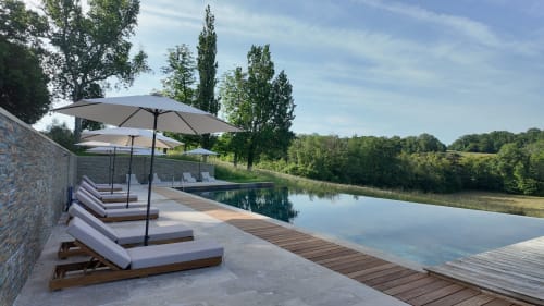 Luxury poolside lounge at Château ERIGOYE in Beychac-et-Caillau with sunbeds, umbrellas and river views