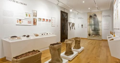 Exhibición de museo de chocolate en La Posada de las Flores en Astorga mostrando historia del cacao, artefactos y sacos de yute