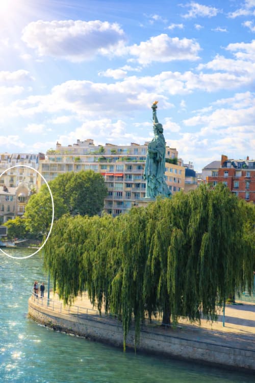 Réplique de la Statue de la Liberté sur une île avec des saules pleureurs, vue sur la Seine avec immeubles colorés