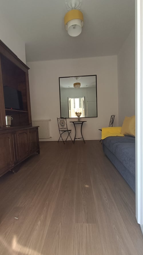 Appartamento Annarella Maison a Roma Casa Tua con pavimenti in legno, letto con cuscini gialli, TV, specchio e vista sulla città