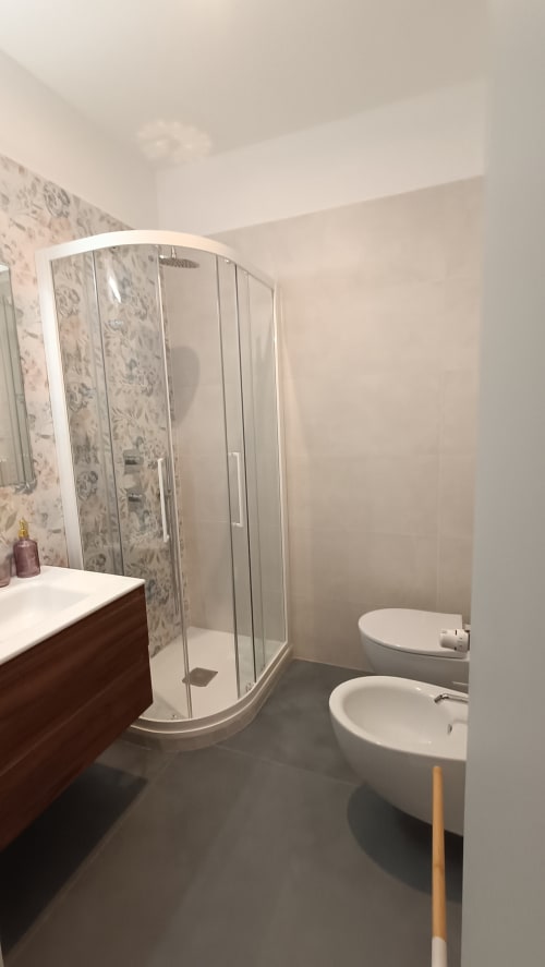 Bagno moderno a Roma Casa Tua con doccia, doppio lavabo e piastrelle decorative