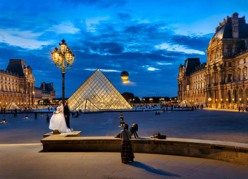 Mariés dans la cour du Louvre à Paris au crépuscule, scène de mariage élégante près des Appartements ATHEA