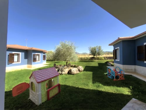 Villa moderna con giardino condiviso, parco giochi per bambini, ulivi e vista sulla campagna a Valledoria