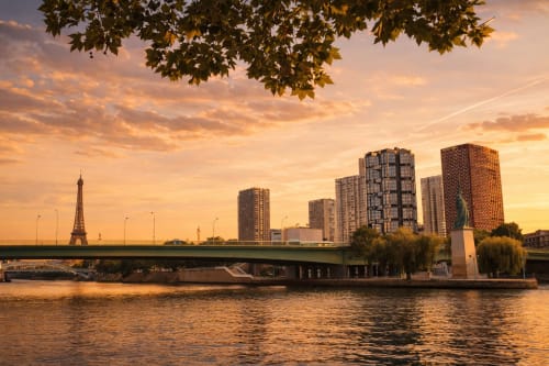 Coucher de soleil doré sur la Seine avec la Tour Eiffel, pont et skyline de Paris près d'ATHEA Appartements