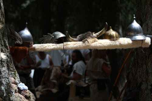 Exposition de casques et cors à thème viking à l'hôtel Skol In Normandy avec des visiteurs flous en arrière-plan