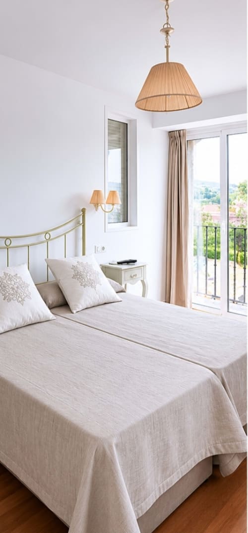 Luminosa habitación Superior en Hostal Doña Blanca con cama de latón, iluminación colgante y vistas a las montañas desde el balcón, Sigüenza