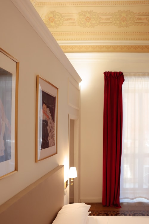 Elegant King Superior bedroom at Casa Beretti Catania with ornate ceiling, framed artwork, red curtains and hardwood floors