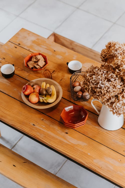 Présentation rustique sur table en bois avec fruits frais, œufs, pain et fleurs séchées aux Granges De Pil Bara, Langoat