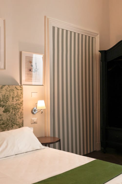 Casa Beretti King Superior bedroom in Catania with striped curtains, accent wallpaper, and reading lamp