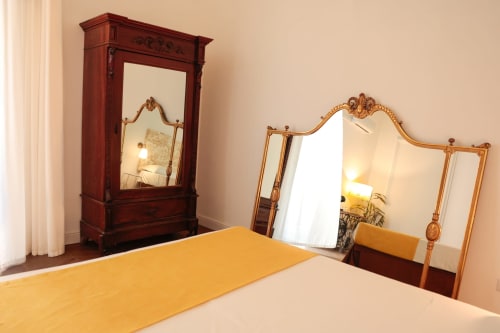 Casa Beretti King Superior bedroom in Catania with antique wooden furniture and ornate mirrors