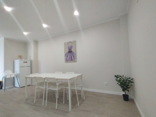 Moderner Essbereich in der Villa-Ti-Neves-Wohnung der Furnaka-Village-Herberge in Lourinhã mit weißem Tisch, Stühlen und Wohnbereich