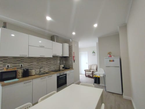 Moderne Küche und Wohnbereich im Apartment Villa Ti Neves der Herberge Furnaka Village in Lourinhã mit weißen Schränken