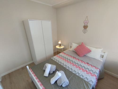 Gemütliches Schlafzimmer in der Herberge Furnaka Village in Lourinhã mit Bett, Kleiderschrank und Willkommensausstattung