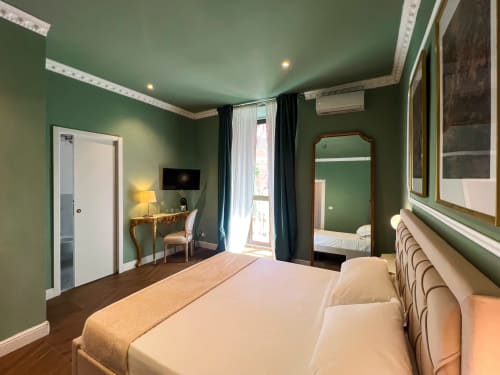 Camera deluxe di Casa Beretti B&B a Catania con pareti verdi, pavimenti in legno e comfort moderni